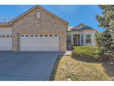 Charming brick home with attached two-car garage and well-maintained front yard at 71 Woodland Cir, Highlands Ranch, CO 80126