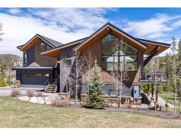 Striking mountain home with a mix of wood and dark siding and a garage beneath a gabled roofline at 2250 Highlands Dr, Breckenridge, CO 80424