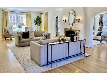 Bright living room with hardwood floors, fireplace, neutral furniture, and lots of natural light at 2215 E 7Th Avenue Pkwy, Denver, CO 80206