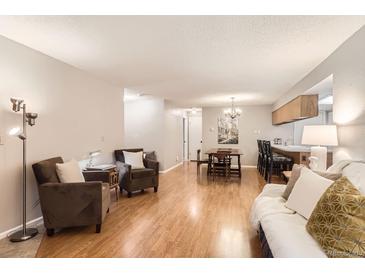 Inviting living room featuring hardwood floors, comfortable seating, and a cozy dining area at 9411 W 89Th Cir, Westminster, CO 80021