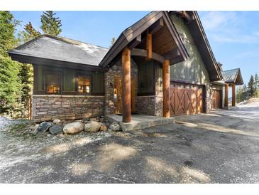 Inviting exterior with stone accents, wood beams, and a three-car garage adds to the curb appeal at 50 Cooney Ct, Breckenridge, CO 80424
