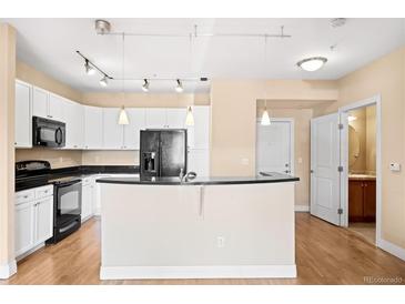 Bright kitchen features white cabinetry, granite countertops, and stainless-steel appliances at 9019 E Panorama Cir # D211, Centennial, CO 80112
