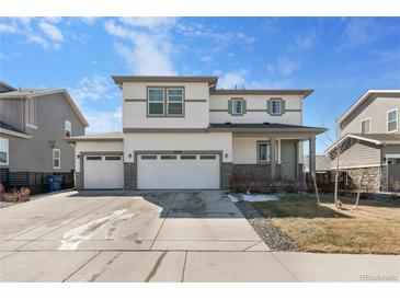 Charming two-story home with a three car garage, white siding, and stone accents at 26818 E 1St Pl, Aurora, CO 80018