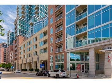 Condominium exterior with a mixture of brick, tan stone, and glass facades along a tree-lined street at 1700 Bassett St # 1102, Denver, CO 80202