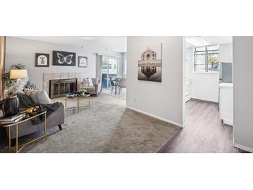 Cozy living room featuring a fireplace, plush seating, and sliding glass doors leading to outdoor space at 12470 E Cornell Ave # 104, Aurora, CO 80014