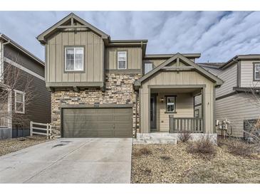 Charming two-story home featuring stone accents, a front porch, a two-car garage, and a well-maintained lawn at 2616 Loon Cir, Castle Rock, CO 80104