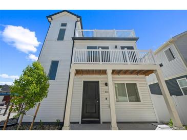 Stunning three-story home featuring a white exterior, balconies, and modern architectural details at 18211 E 51St Ave, Denver, CO 80249