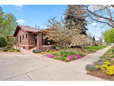 Charming brick home with a manicured front yard, blooming trees, and a welcoming entrance at 1439 S Emerson St, Denver, CO 80210