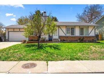 Charming single-story home featuring a well-manicured lawn, brick accents, and a quaint covered front entrance at 16650 E Nassau Dr, Aurora, CO 80013