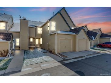 Townhome exterior with attached garages, neutral paint, blue trim and sunset sky at 10329 W Fair Ave # C, Littleton, CO 80127