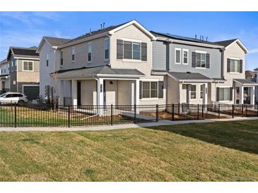 Attractive townhomes with a black metal fence and lush green lawn in a well-maintained community at 27492 E 1St Ave, Aurora, CO 80018