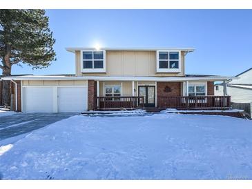 Two-story house with attached garage and snow-covered front yard at 10350 W Burgundy Ave, Littleton, CO 80127