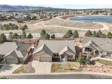 Beautiful ranch-style home with well-manicured landscaping and a three car garage in a desirable location near a lake at 1520 Symphony Hts, Monument, CO 80132