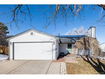 White house with green door, two-car garage, and solar panels at 2719 S Truckee St, Aurora, CO 80013