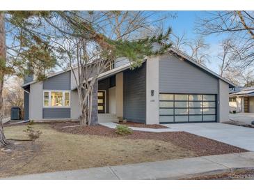 Modern home exterior boasts gray siding, glass garage door, and well-maintained landscaping with mature trees at 2201 Juniper Ct, Boulder, CO 80304