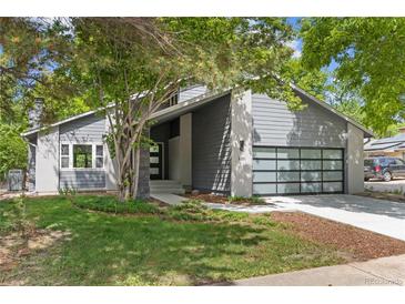 Modern gray home featuring a stylish garage door, manicured lawn and front yard landscaping at 2201 Juniper Ct, Boulder, CO 80304
