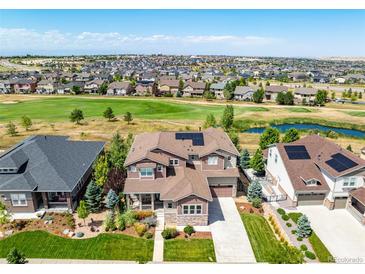 Aerial view of a two-story house with solar panels, situated in a neighborhood near a golf course at 7609 S Country Club Pkwy, Aurora, CO 80016