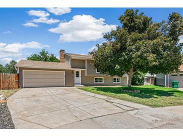 Charming home with a well-manicured lawn and a spacious driveway leading to a two-car garage on a sunny day at 8539 W Duquesne Dr, Lakewood, CO 80227