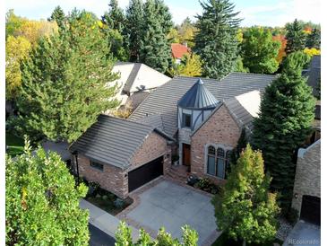 Stunning brick home with a turret, tile roof, mature trees, and a well-manicured front yard at 106 S University Blvd # 5, Denver, CO 80209