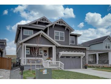 Beautiful two-story home featuring stone accents, a welcoming porch, and well-maintained landscaping at 1031 Turnberry Cir, Louisville, CO 80027