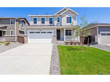 Charming two-story home with a well-maintained lawn, two car garage, and inviting curb appeal at 18971 E 96Th Pl, Commerce City, CO 80022