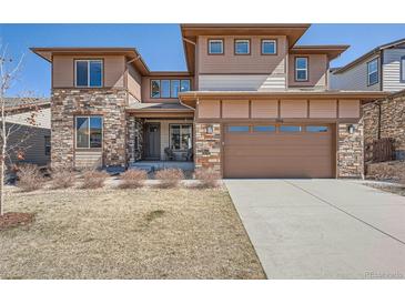 Beautiful two-story home with a two car garage, stone accents, and an inviting front yard at 7994 S Kewaunee St, Aurora, CO 80016