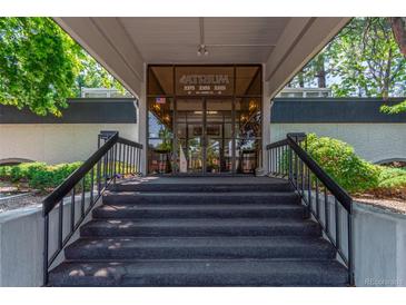 Building entrance with glass doors, stairs, and black railings offering easy access and a welcoming aesthetic at 2325 S Linden Ct # 206, Denver, CO 80222