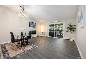 Bright living room with sliding doors to balcony, dining area, fireplace, and modern flooring at 650 S Clinton St # 6D, Denver, CO 80247