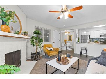 Cozy living room with a white brick fireplace, plush seating, and lots of natural light at 14652 E 2Nd Ave # 200, Aurora, CO 80011