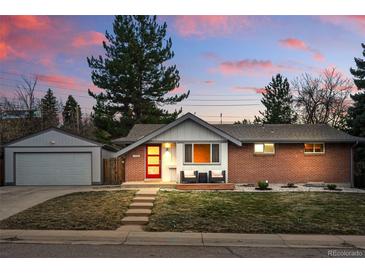 Charming brick home featuring a red door, landscaped front yard and detached garage at 2958 E Euclid Pl, Centennial, CO 80121