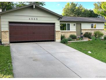 Charming single-story home with a well-manicured lawn, beautiful plants and a large driveway at 4665 E Peakview Ave, Centennial, CO 80121
