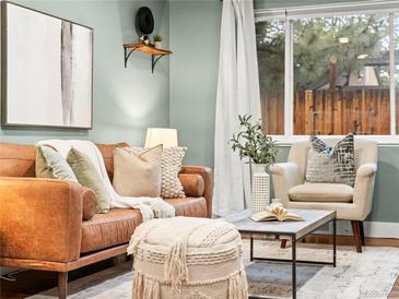 Cozy living room featuring a leather sofa, decorative pillows, and large window views at 3555 Leyden St, Denver, CO 80207