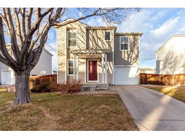 Two-story house with a red door and attached garage at 1469 Hummingbird Cir, Brighton, CO 80601