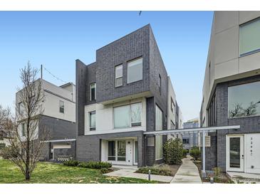 Modern townhome with a brick facade, a well-maintained lawn, and a paved walkway to the front door at 3256 Federal Blvd, Denver, CO 80211