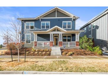 Charming two-story home with a covered front porch and manicured front yard at 7903 E 50Th Dr, Denver, CO 80238