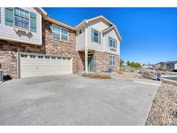 A charming townhome featuring a stone facade and a spacious two-car garage at 7243 S Millbrook Ct # F, Aurora, CO 80016