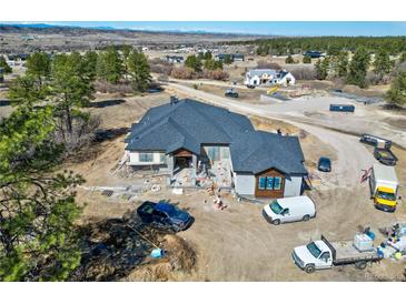 A beautiful home in progress, featuring a modern roof design and spacious construction site nestled in a scenic landscape at 1555 Arrowpoint Ct, Franktown, CO 80116