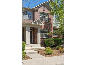 Charming brick townhome featuring a well-manicured front yard and inviting front porch at 7440 E 8Th Ave # 25, Denver, CO 80230