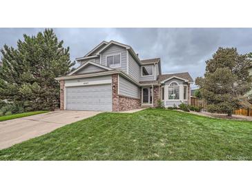 Charming two-story home with a well-manicured lawn, attached garage, and appealing curb appeal at 4567 Flanders Way, Denver, CO 80249