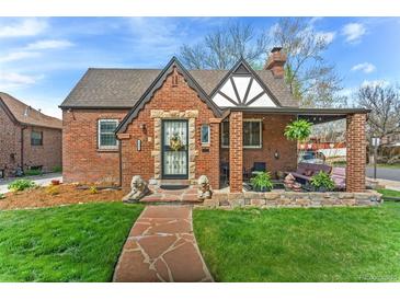 Charming brick home with a well-manicured lawn and a cozy covered porch perfect for relaxing at 2995 Albion St, Denver, CO 80207