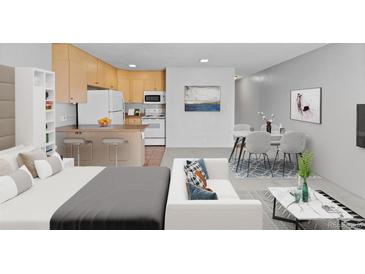 Open-concept living room, kitchen, and dining area with a breakfast bar and modern decor create an inviting and functional space at 2500 S York St # 310, Denver, CO 80210