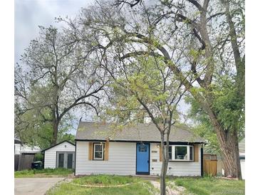 Charming single-story home with white siding, a bright blue front door, and mature trees in the front yard at 4745 S Sherman St, Englewood, CO 80113