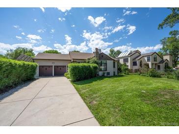 Charming home with a well-maintained front yard, driveway, and a two-car garage at 675 Holland St, Lakewood, CO 80215