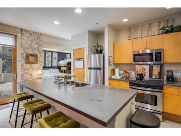 Modern kitchen with stainless steel appliances, bar seating, and an open layout to the bedroom at 801 Confidence Dr # 2, Longmont, CO 80504