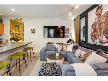Stylish living room features modern fireplace, large sectional sofa, and unique wall art at 801 Confidence Dr # 2, Longmont, CO 80504