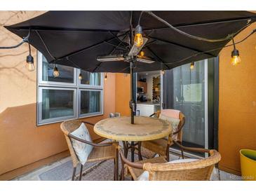 Cozy patio seating area with an umbrella, cafe lights and an outdoor heater at 801 Confidence Dr # 2, Longmont, CO 80504