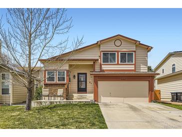 Charming two-story home with well-maintained lawn, covered porch with seating and two-car garage, nestled in a residential neighborhood at 6367 Xavier St, Arvada, CO 80003