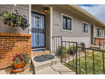 Charming front door with flower basket and brick accents, creating a welcoming entrance to the home at 4028 Ames St, Wheat Ridge, CO 80212