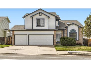 Charming two-story home with a two-car garage, manicured lawn, and beautiful architectural details at 3823 S Uravan St, Aurora, CO 80013