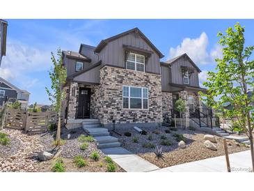 Charming townhouse with a stone facade, landscaped front yard, and modern architectural details at 8145 Monte Vista Cir, Littleton, CO 80125